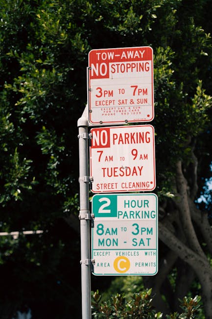 A tall metal street sign post displaying three parking and stopping restriction notices. The top sign is red and white, indicating tow-away zones and no stopping from 3 pm to 7 pm with exceptions for